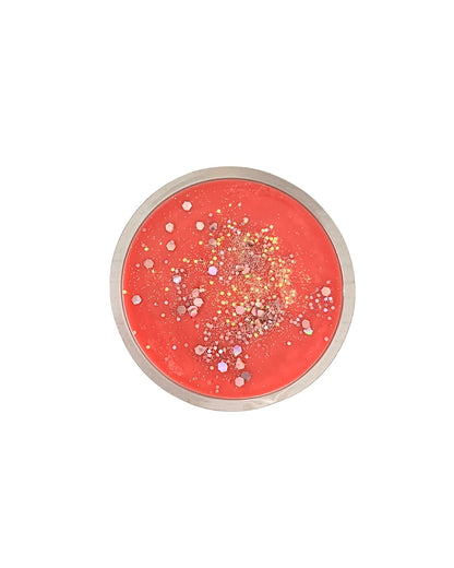 Round wax melt with glittery center on a white background
