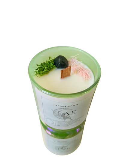 Candle in a glass container with decorative elements on a white background