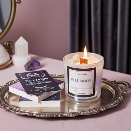Candle labeled 'Full Moon' on a tray with books and crystals in a decorative setting.