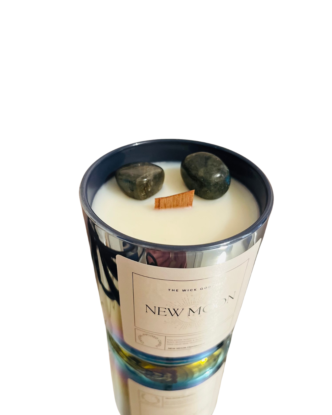 Candle with decorative stones on top labeled 'New Moon'.