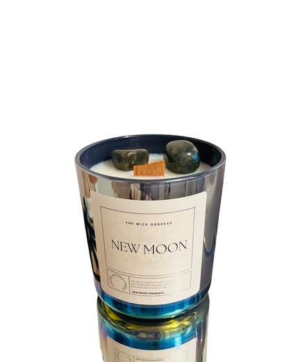 Candle labeled 'New Moon' with decorative stones on a white background